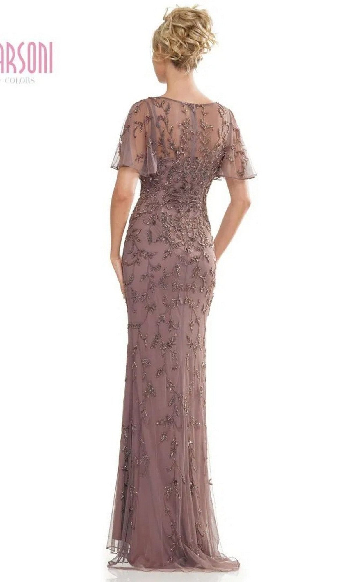 A woman stands with her back to the camera wearing the Marsoni MV1281, a mauve floor-length formal dress featuring short sleeves, lace and sequin details, and an illusion sweetheart neckline.